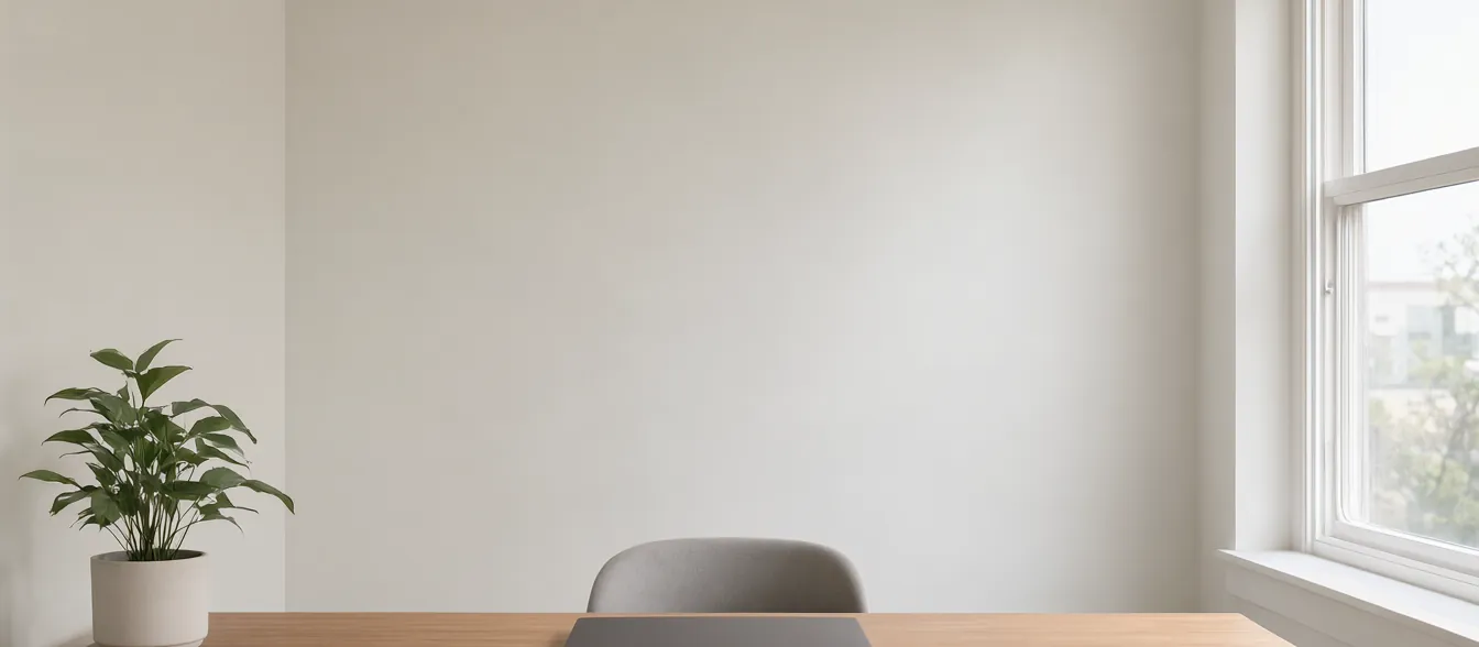 A quiet office with a desk, paperwork and a window.