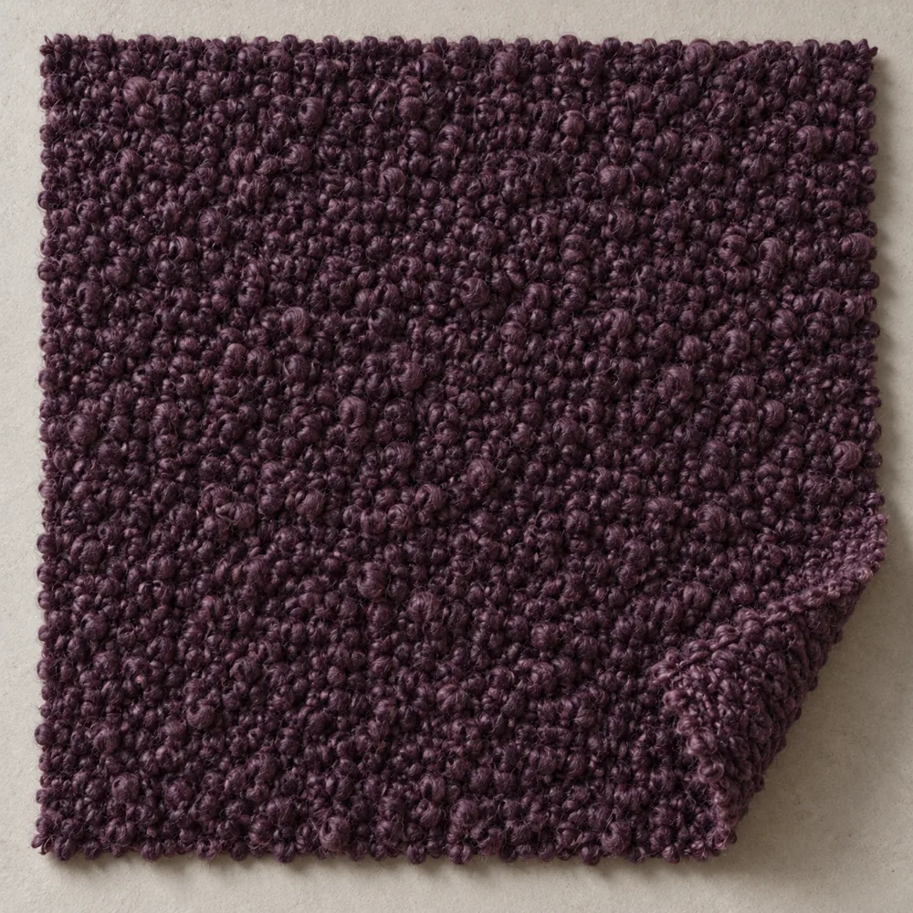 Deep aubergine wool bouclé with a dense looped surface and soft thick edge.