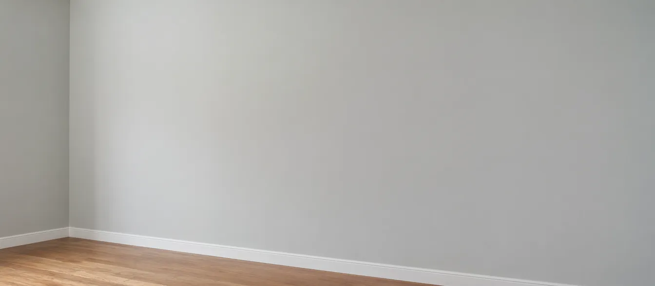 A freshly painted living room with pale gray walls and white trim.